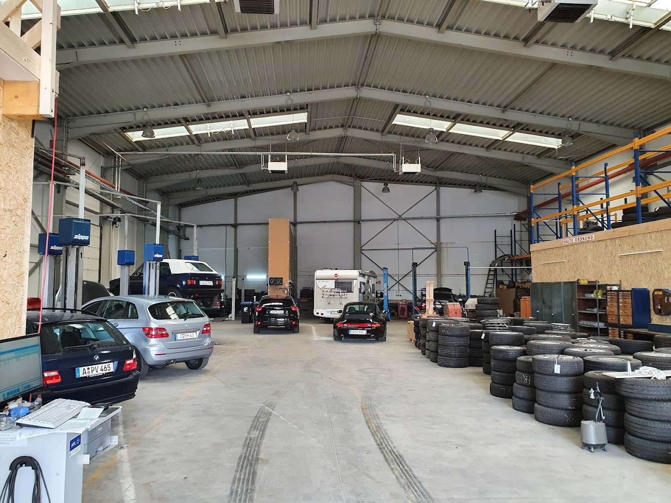 Werkstatthalle von Tellmann & Becker mit Fahrzeugen auf der Hebebühne