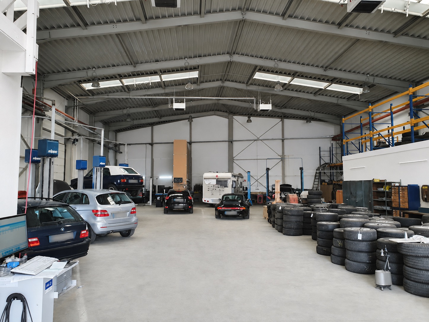 Werkstatthalle von Tellmann & Becker mit Fahrzeugen auf der Hebebühne